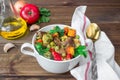 Served beef meat stewed with vegetables in ceramic pot with ingredients on wooden background Royalty Free Stock Photo