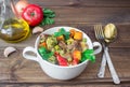 Served beef meat stewed with vegetables in ceramic pot with ingredients on wooden background Royalty Free Stock Photo