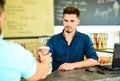 Served coffee to go. Barista at bar of modern cafe ready serve coffee for client. Barista handsome stylish hipster Royalty Free Stock Photo