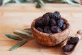 Served dried black olives in wooden olive bowl