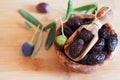 Served dried black olives in wooden olive bowl