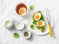 Served Easter brunch plate - grilled bread sandwich with spinach and boiled eggs and lemon tea on white background Royalty Free Stock Photo