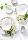 Served empty table with white crockery, flowers, napkins on white background, top view. Cozy home serving food table Royalty Free Stock Photo