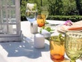 Served festive table. Wedding serving. White tablecloth with plates and decor in garden. Wedding concept