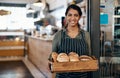 Served fresh just for you. a young woman holding a selection of freshly baked breads in her bakery. Royalty Free Stock Photo