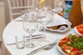 Served for holiday banquet restaurant table with dishes, snack, cutlery, wine and water glasses Royalty Free Stock Photo