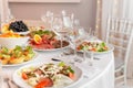 Served for holiday banquet restaurant table with dishes, snack, cutlery, wine and water glasses Royalty Free Stock Photo