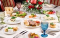 Served for holiday banquet restaurant table with dishes, snack, salads, cutlery, wine and water glasses. European food in a