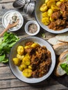 Served lunch table - irish beef stew with bombay turmeric potatoes. Delicious seasonal food on a wooden background, top view.