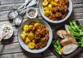 Served lunch table - irish beef stew with bombay turmeric potatoes. Delicious seasonal food on a wooden background, top view.