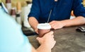 Served in paper cup coffee to go. Hand of barista at bar serve coffee for client. Hand gives cup to client visitor Royalty Free Stock Photo