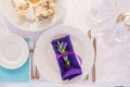 Served plate with Cutlery and a bright purple napkin with a sprig of eucalyptus in the decor of a wedding dinner Royalty Free Stock Photo