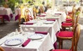 Served restaurant tables and chairs outside in the central street of Sanremo, Italy. Royalty Free Stock Photo