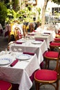 Served restaurant tables and chairs outside in the central street of Sanremo, Italy. Royalty Free Stock Photo