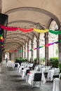 Served restaurant tables outside in the arcades in Passeig Colom, corridor architecture of Barcelona