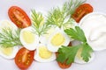 An overhead photo of vegetable salad with mayonnaise, boiled quail egg, dill, fresh tomato and parsley on white porcelain plate. A Royalty Free Stock Photo