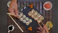 Served A Set Of Sushi With Salmon And Tuna, California Rolls, Maki, Soy Sauce Closeup On The Table. Hands eat sushi with chopstick Royalty Free Stock Photo