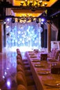 Served table with blue balloons on illuminated scene at restaurant.