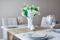 Served table with a bouquet of roses in interior of modern luxure guest room in studio apartments in minimalistic style