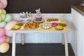 Served table with many shelfs of snacks sweets and a birthday cake