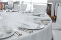 Served table in the restaurant. clean white dishes layout on a white tablecloth Royalty Free Stock Photo