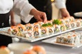 server arranging freshly rolled sushi on a platter for a buffet table Royalty Free Stock Photo