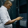 Server room, black man or technician with tablet for online cyber security glitch or software error. IT support, digital Royalty Free Stock Photo