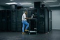 Server room, database and information technology with an engineer man at work on a network mainframe. Computer