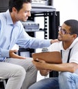 Server room, man or technician with clipboard talking to a client about cyber security glitch or hardware. Network, help