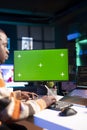 Server technician optimizing program and next to green screen