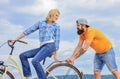 Service and assistance. Man helps keep balance ride bike. Girl cycling while man support her. Support helps believe in Royalty Free Stock Photo