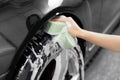 Service car wash express. Girl worker clean tire and rubber wheel with sponge Royalty Free Stock Photo