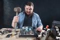 Service engineer with hammer, laptop on the desk Royalty Free Stock Photo