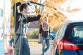 Service man helping woman cleaning her auto in car wash Royalty Free Stock Photo