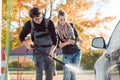 Service man helping woman cleaning her auto in car wash Royalty Free Stock Photo