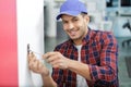 Service man installing power socket in wall with screwdriver