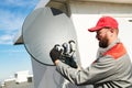 Service worker installing and fitting satellite antenna dish for cable TV Royalty Free Stock Photo