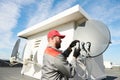 Service worker installing and fitting satellite antenna dish for cable TV Royalty Free Stock Photo