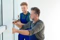 Service men measuring window for installation Royalty Free Stock Photo