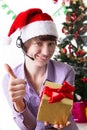 Service operator on Christmas back showing ok sign with present