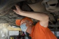 Service repair maintenance concept. A car mechanic wearing a mask is holding a laptop to check the car`s performance Royalty Free Stock Photo