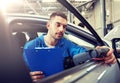 Mechanic man with diagnostic scanner at car shop Royalty Free Stock Photo