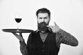 Service and restaurant catering concept. Man and mustache holds alcohol on white background. Waiter points at tray and Royalty Free Stock Photo