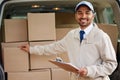 Service with a smile. Portrait of a friendly delivery man standing next to a van full of boxes.