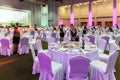 Service staff of Gorky Gorod resort ready to welcome guests standing still among round tables and chairs covered with white