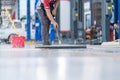 Service staff man using a mop to remove water in the uniform cleaning the protective clothing of the new epoxy floor in an empty