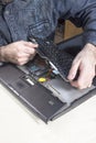 The man dismantles the laptop casing in the electronic equipment service. Royalty Free Stock Photo