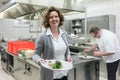 Service waitress in restaurant getting dish from pass in kitchen Royalty Free Stock Photo