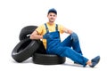 Service worker in blue uniform sitting on tires Royalty Free Stock Photo