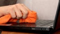 Service worker cleaning laptop keyboard buttons with microfibre cloth Royalty Free Stock Photo